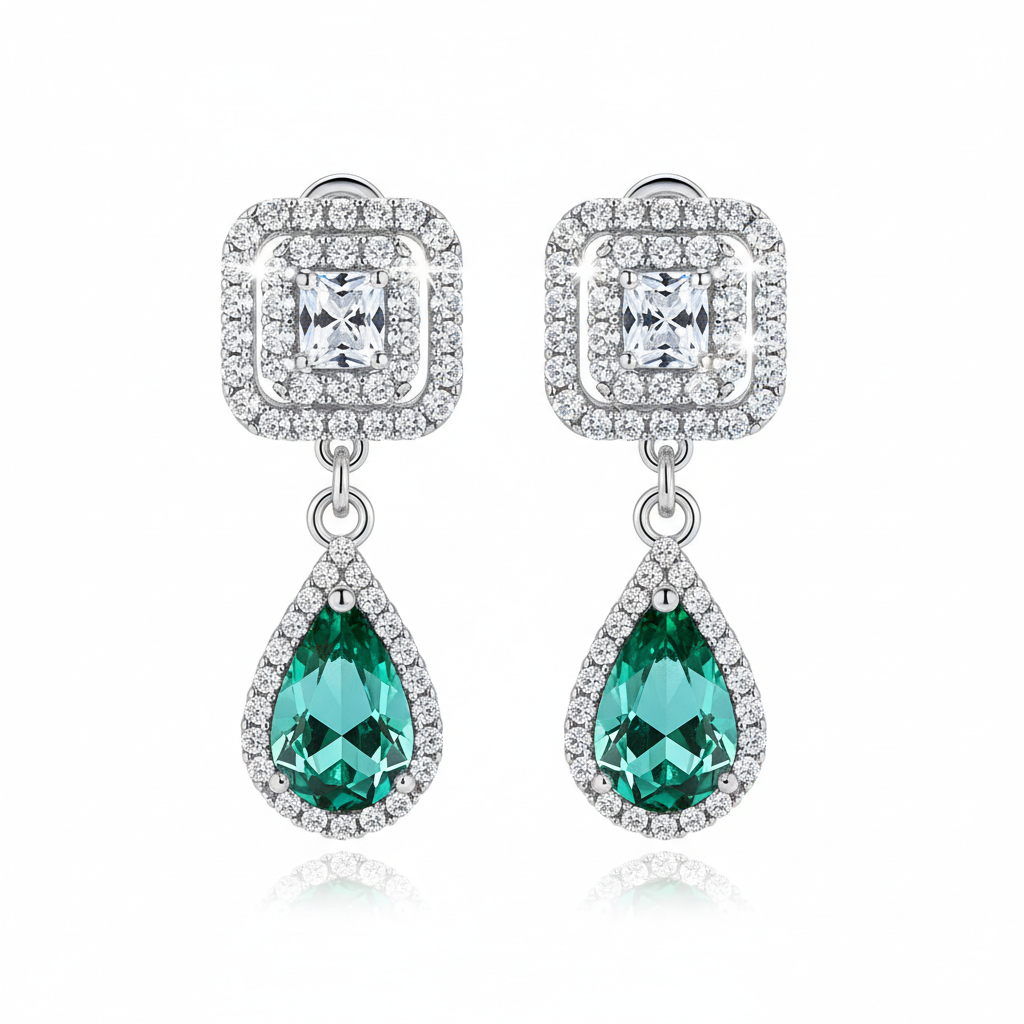 Pair of earrings with green teardrop stones and diamond-like crystals on a white background