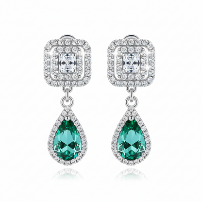Pair of earrings with green teardrop stones and diamond-like crystals on a white background