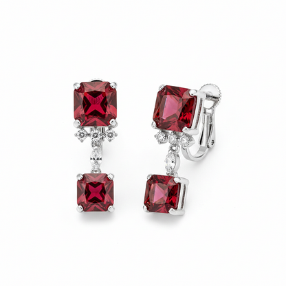 Pair of earrings with red gemstones on a white background