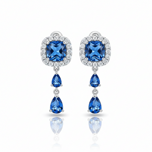 Pair of blue gemstone earrings with silver accents on a white background